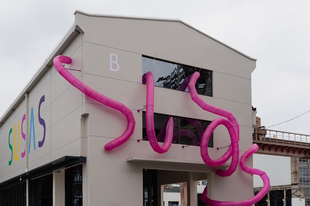 services-03 inflatable-pink-tubes-on-a-building-with-colorful-text-ax9mfw4muq
